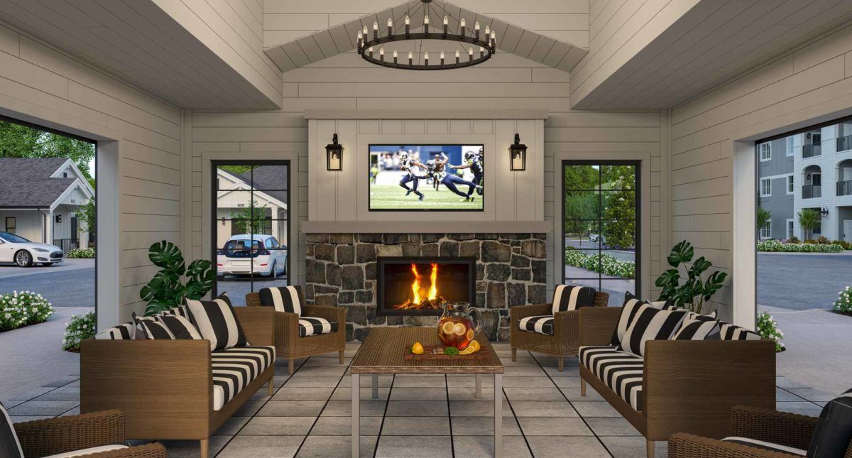 A modern living room featuring a central fireplace, with a TV mounted above it and surrounded by comfortable seating.