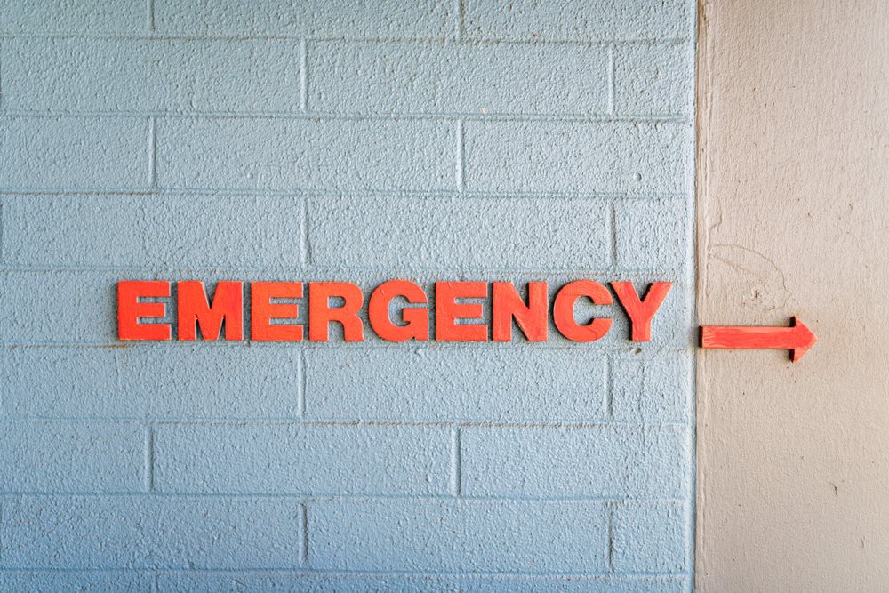 A bold emergency sign on a blue wall.