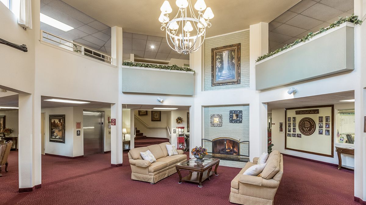 A stylish lobby with comfortable sofas, a grand chandelier, and a fireplace.