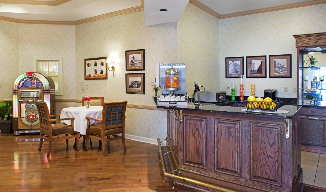 A cozy dining area with a breakfast bar featuring a coffee machine and various drink options.