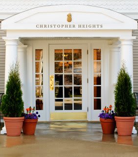 Entrance of a building with potted plants and glass door.