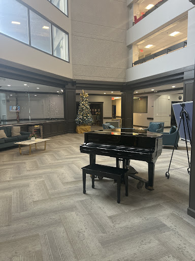 A modern lobby featuring a grand piano and comfortable seating arrangements.