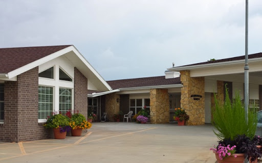 A charming entrance to a modern residential building surrounded by vibrant flowers.