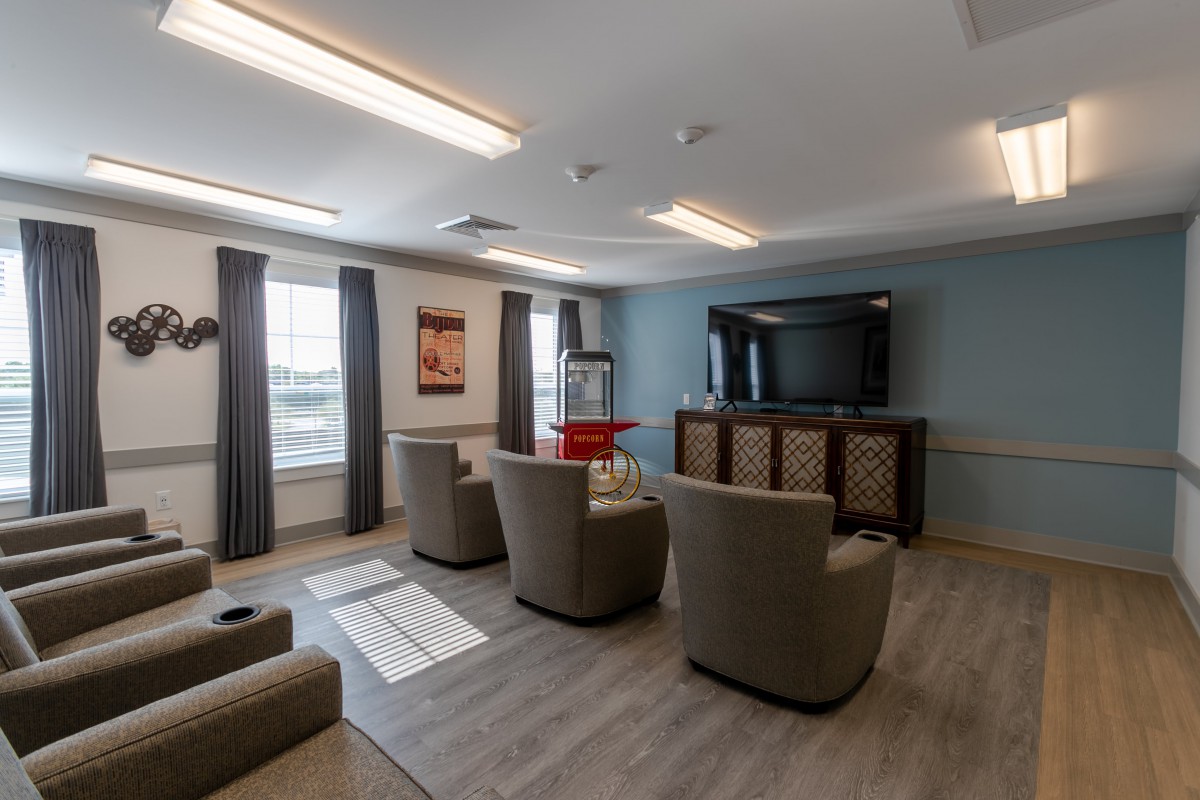 A cozy living room with comfortable seating, a large TV, and a popcorn machine.