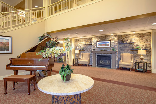 A warm and inviting lobby featuring elegant seating, a piano, and tasteful decorations.