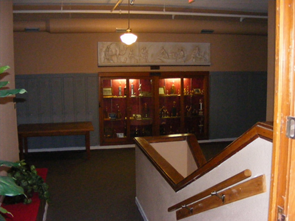 A dimly lit hallway featuring a staircase and a display case.