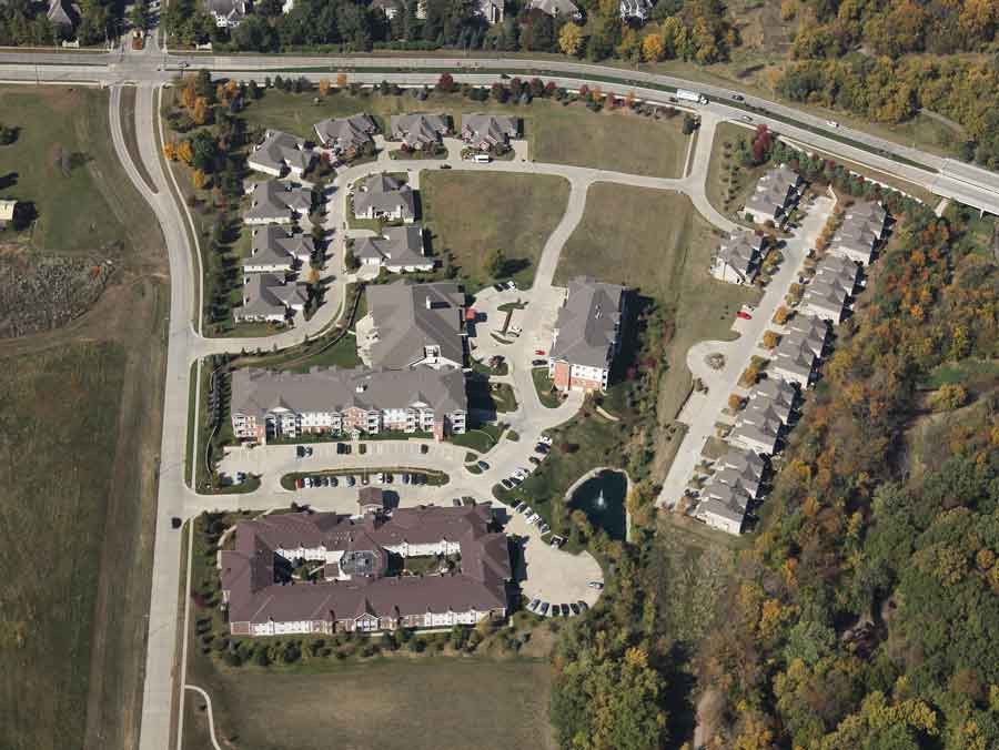 Aerial view of a residential housing complex surrounded by roads and greenery.