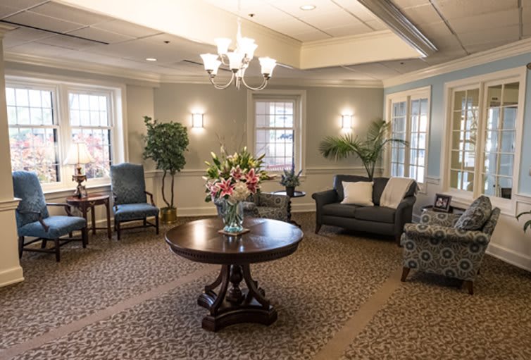 A well-decorated living room featuring elegant furniture and a central flower arrangement.