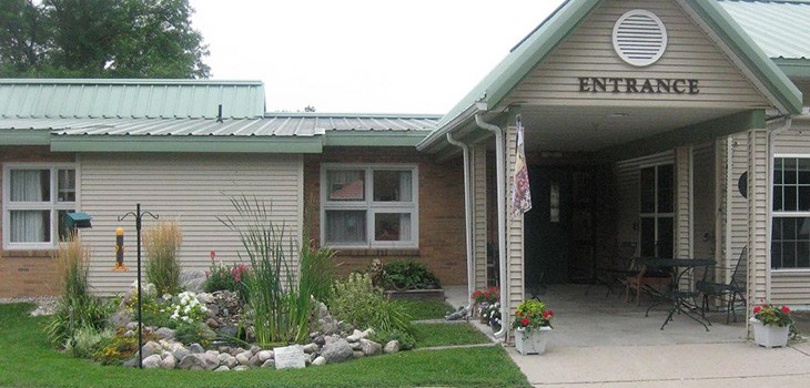 A building entrance with a neatly maintained garden at the front.