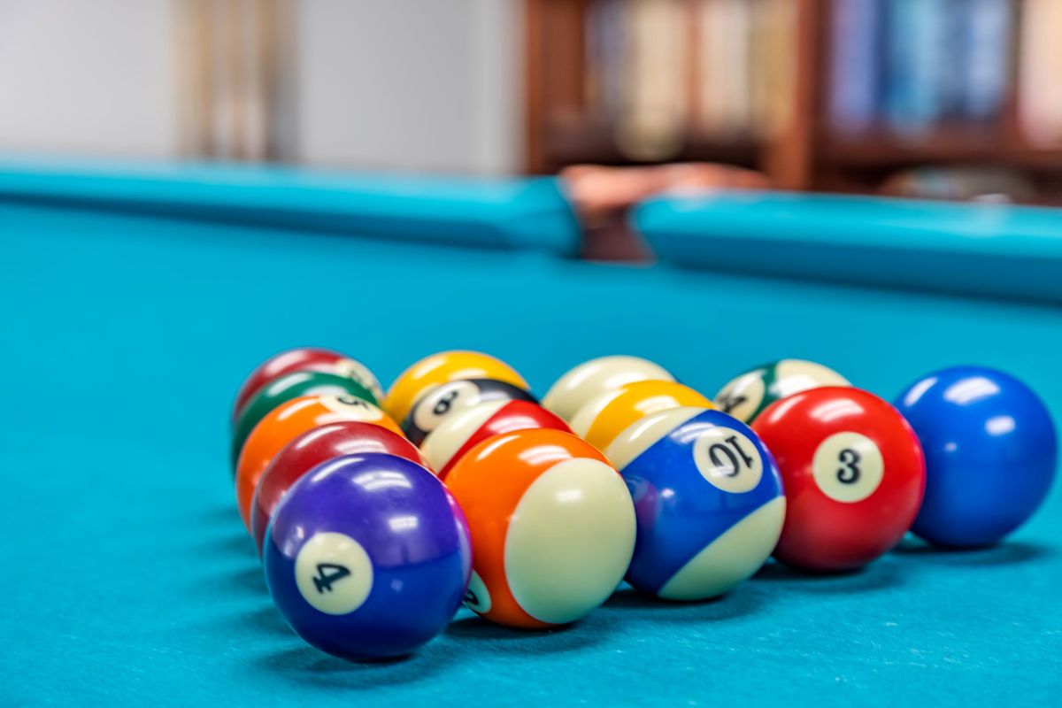 A set of billiard balls arranged on a pool table, ready for a game.