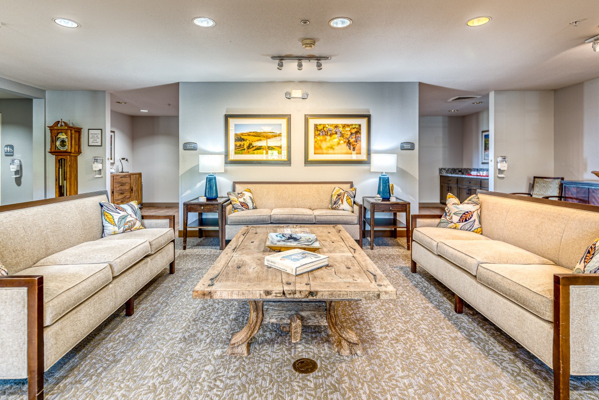 A stylish and well-decorated living room featuring two sofas, a wooden coffee table, and artwork on the wall.