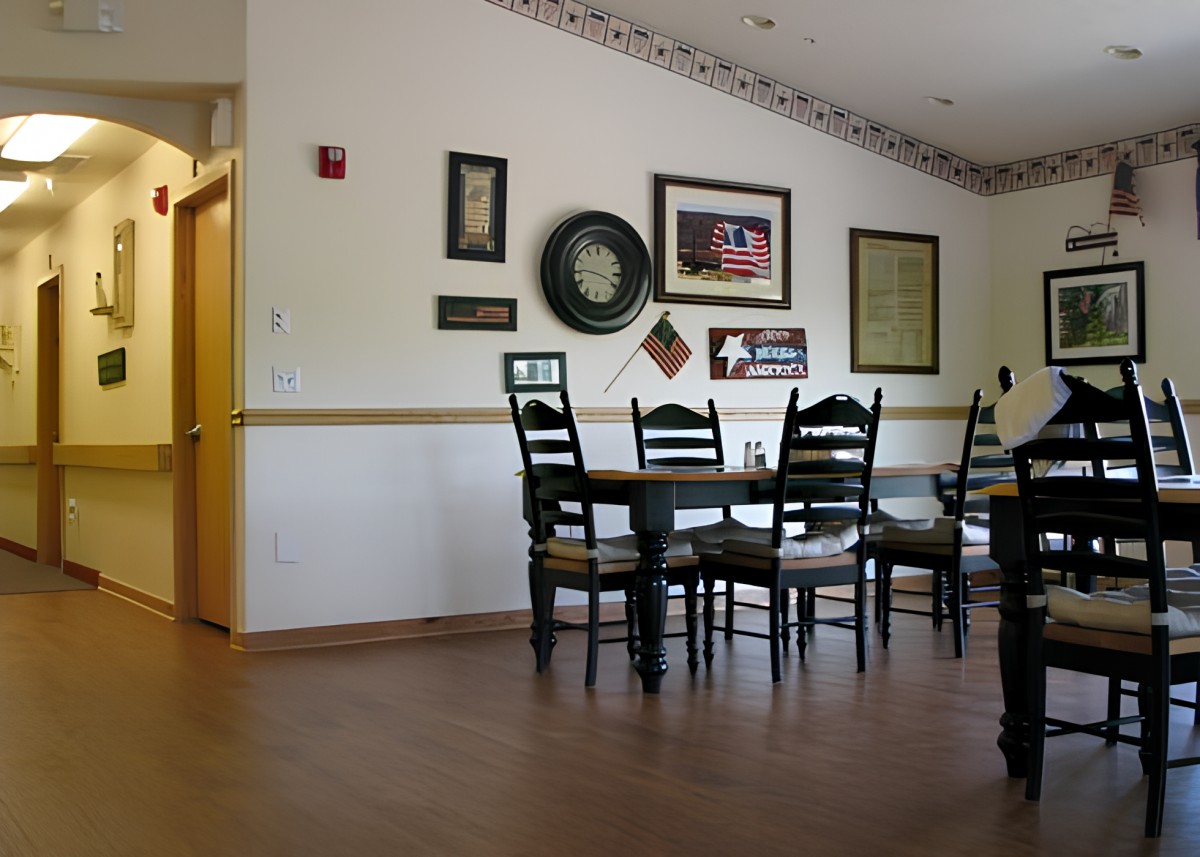 A cozy dining area with a table and chairs, adorned with decorative wall art.