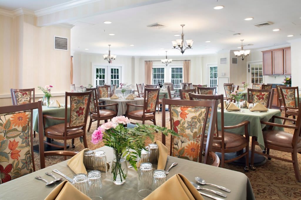 An elegantly set dining room with floral arrangements and classic decor.