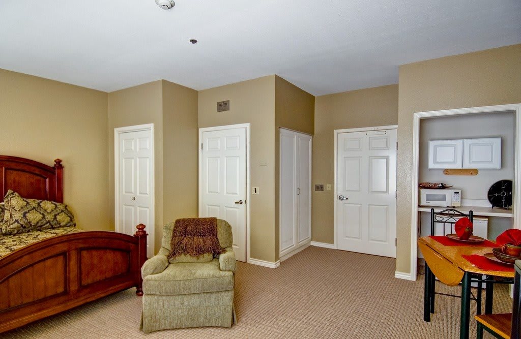 A cozy living room with a comfortable chair and multiple doors.