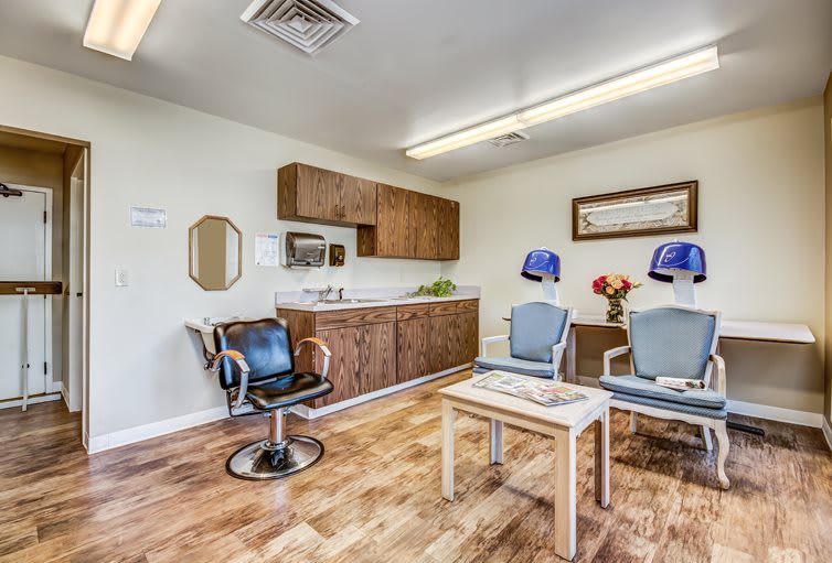 A well-lit salon interior with seating, hair dryers, and a neat waiting area.