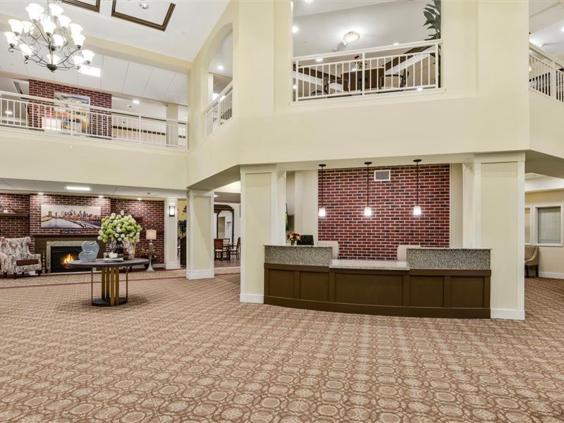 A spacious hotel lobby with a reception desk and elegant interior design.