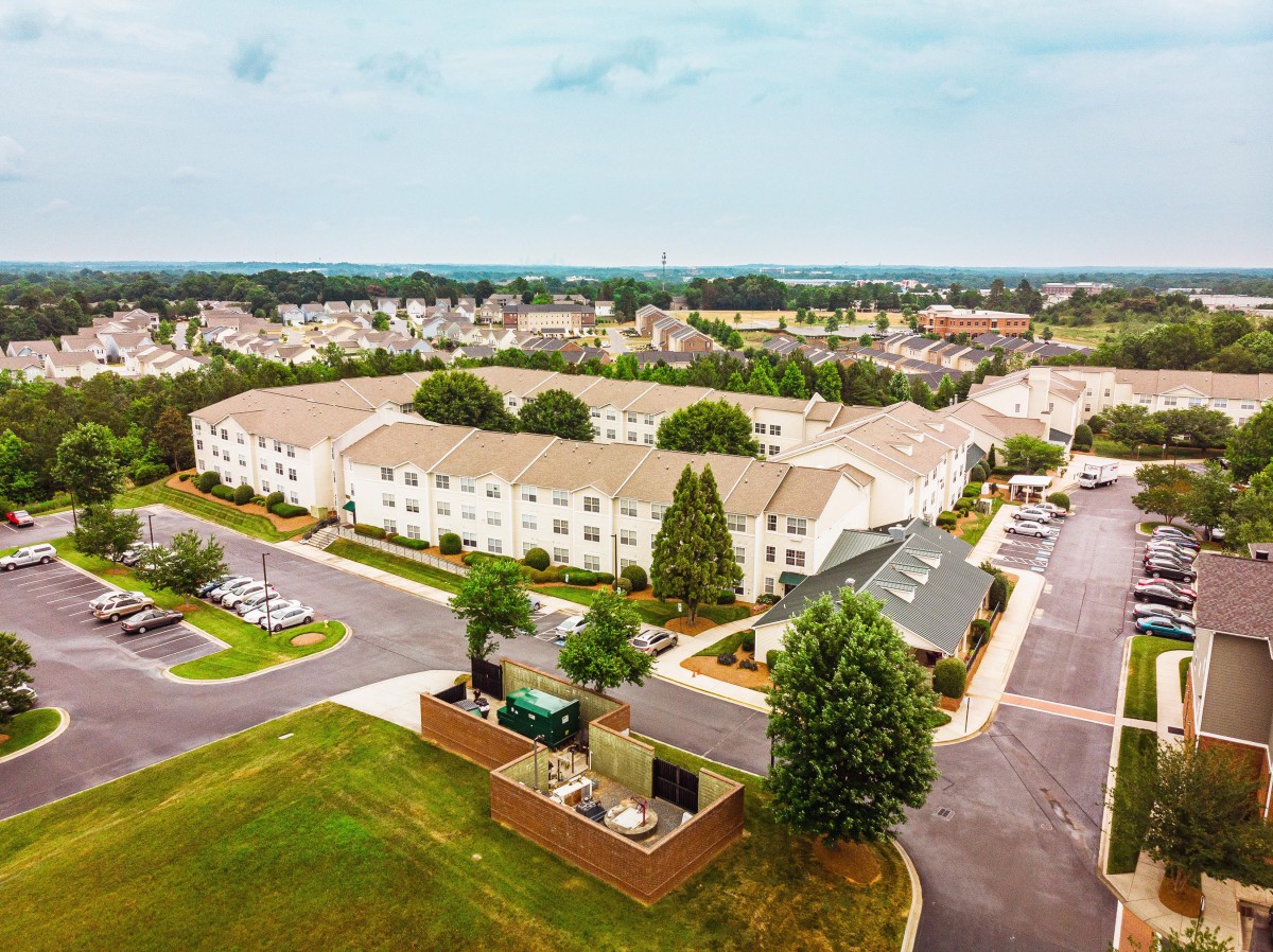 Aerial view of a suburban neighborhood with residential buildings and green spaces.