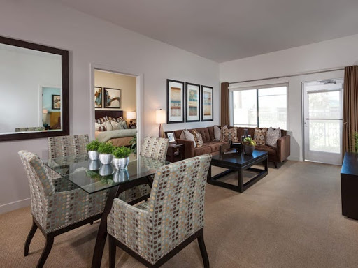 A stylish and modern living room with a dining space, featuring elegant furniture and decor.