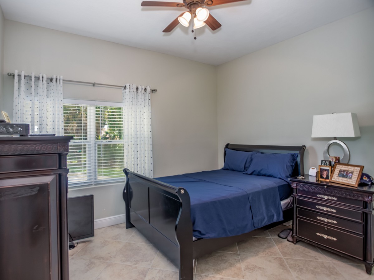 A cozy bedroom with a navy blue bedspread and wooden furniture.