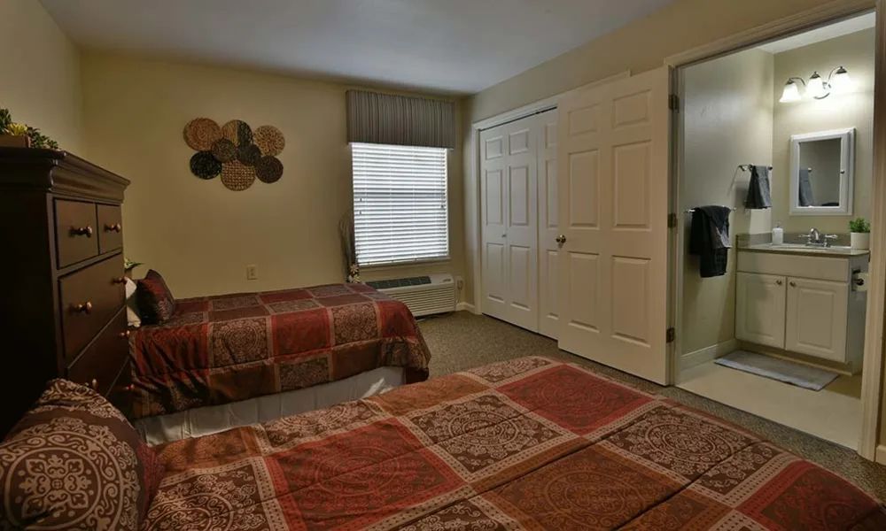 A cozy bedroom with two beds and warm decor.