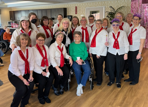 A joyful group of choir members dressed in white shirts and red scarves, gathered together for a special performance.