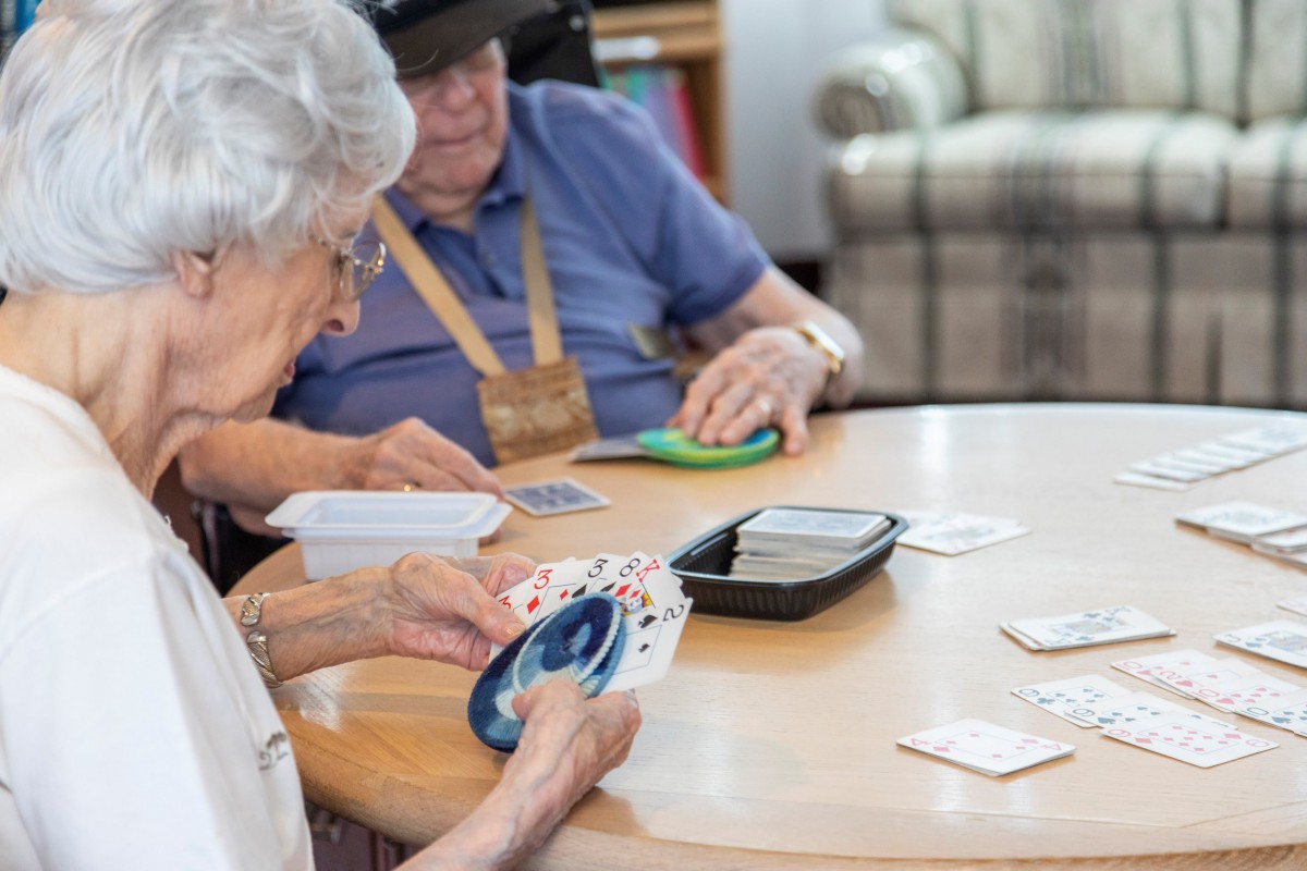 Seniors enjoying a card game at a table.