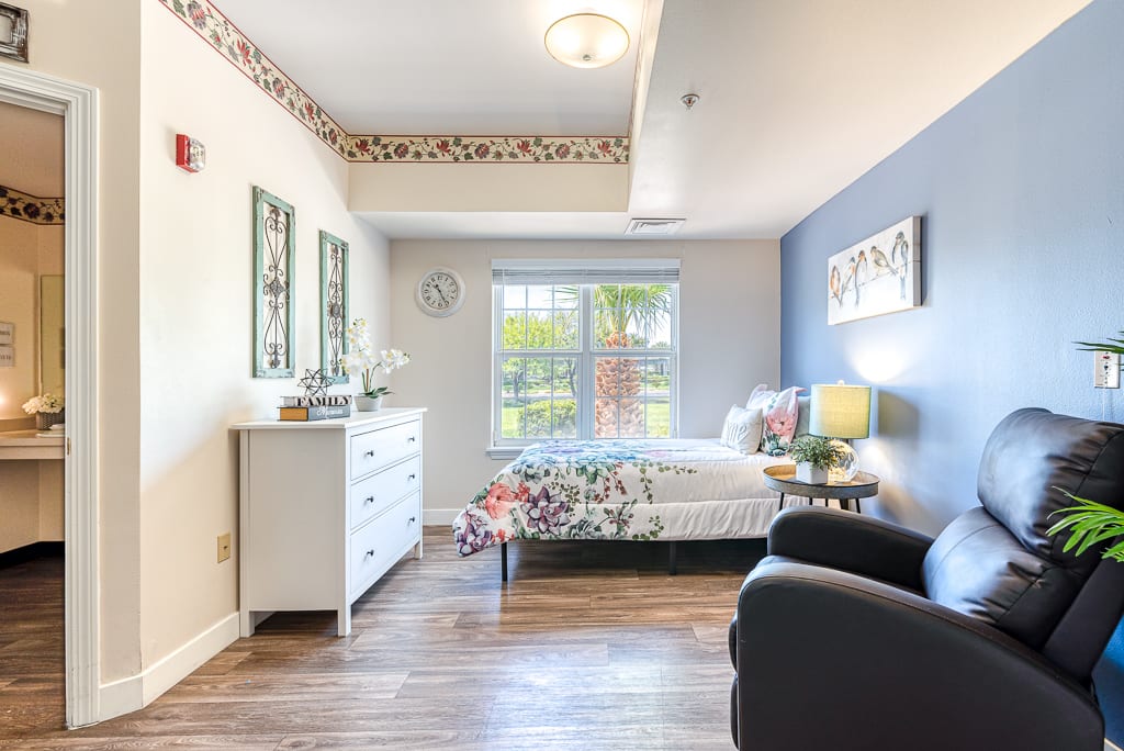 A cozy and modern bedroom with a large window allowing natural light to fill the space.
