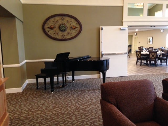 A cozy living room featuring a grand piano and stylish decor.