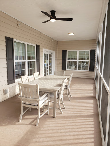 A cozy screened patio featuring a dining table and chairs, perfect for outdoor gatherings.