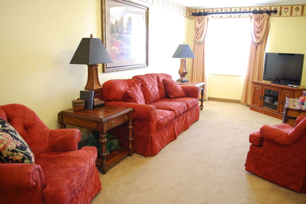A cozy living room with red sofas and warm lighting.