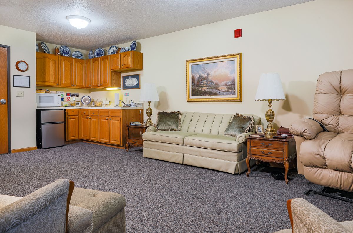 A cozy living room with a sofa and kitchenette.