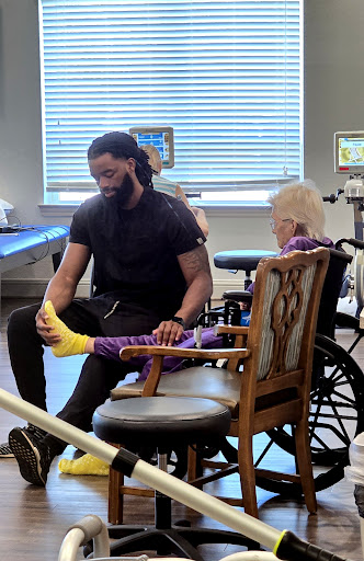 A caregiver assisting a young patient with physical therapy in a rehabilitation setting.
