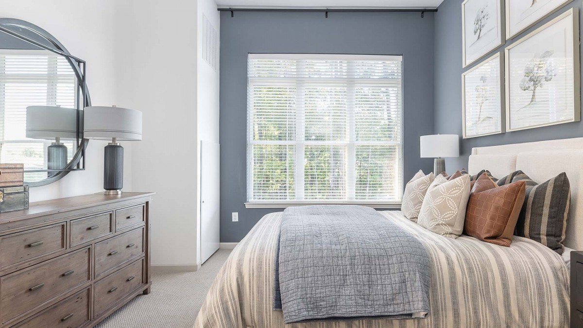 A modern, minimalist bedroom featuring natural light and neutral-toned decor.