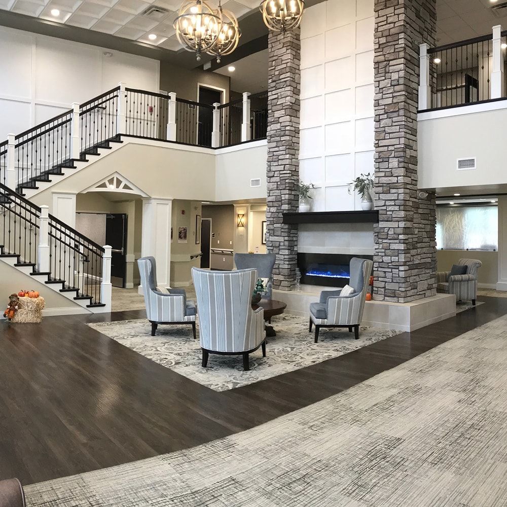 A modern and spacious lobby with a central fireplace, stylish seating area, and elegant chandeliers.