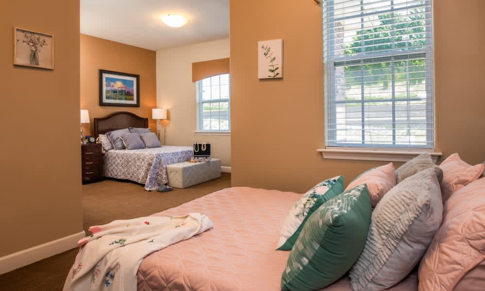 A cozy bedroom with twin beds, adorned with comfortable pillows and soft lighting.