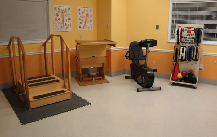 A rehabilitation room equipped with exercise equipment and therapy tools.