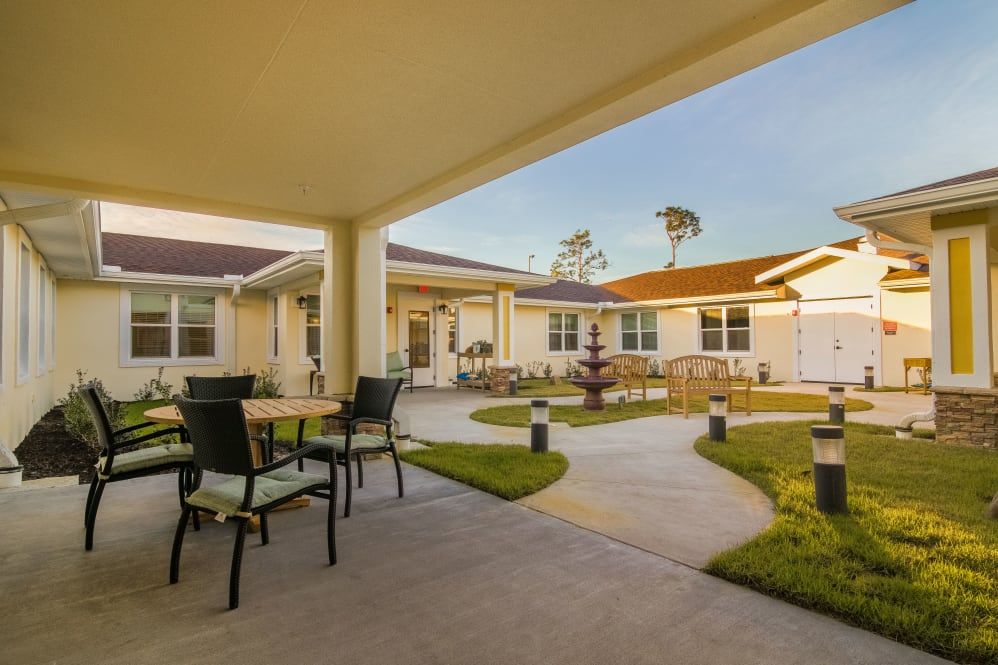 A spacious courtyard with outdoor seating and a view of a well-maintained building.