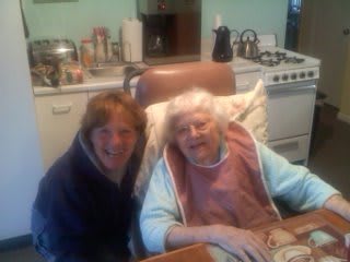 Two people smiling in a cozy kitchen setting.