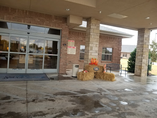 An inviting entrance decorated with pumpkins and hay bales, welcoming the fall season.