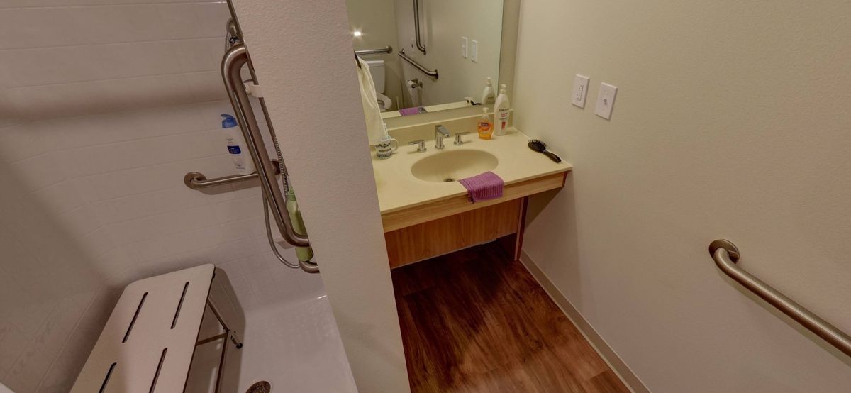 A modern bathroom with a countertop sink, mirror, and towel.
