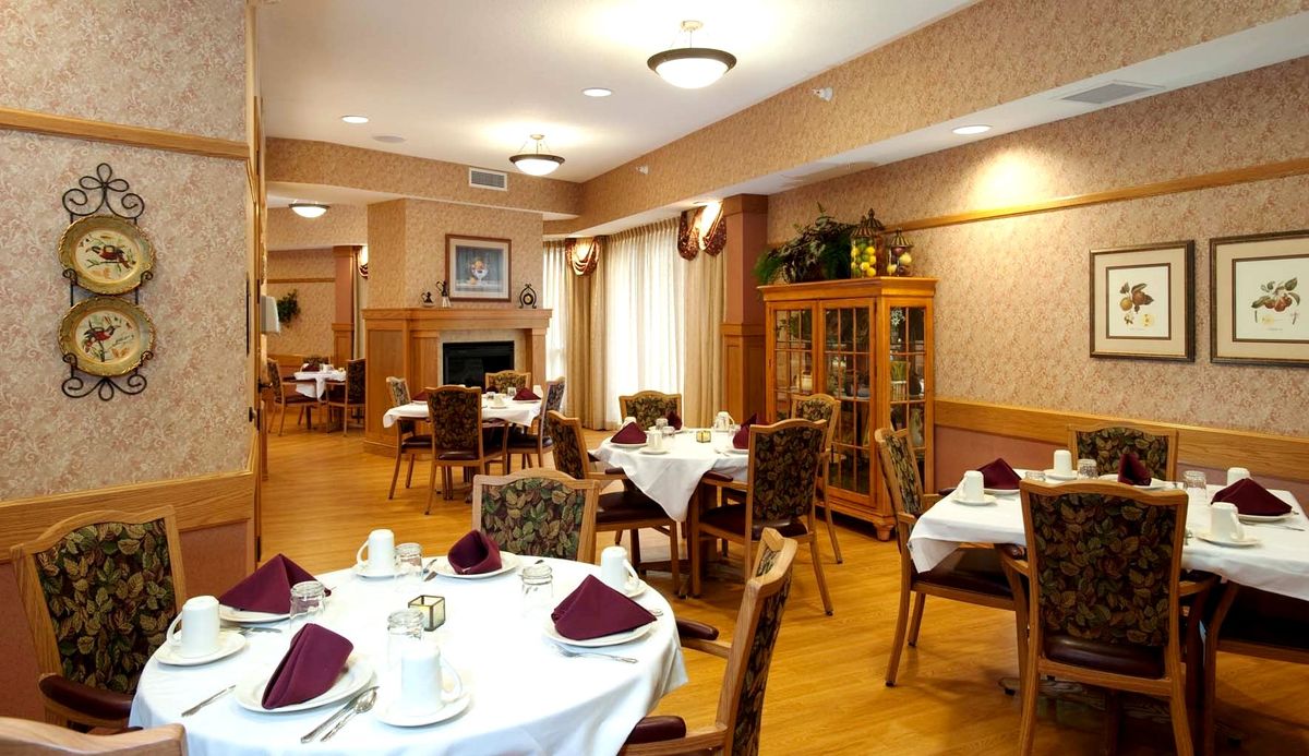 An elegantly set dining room with neatly arranged tables and chairs.