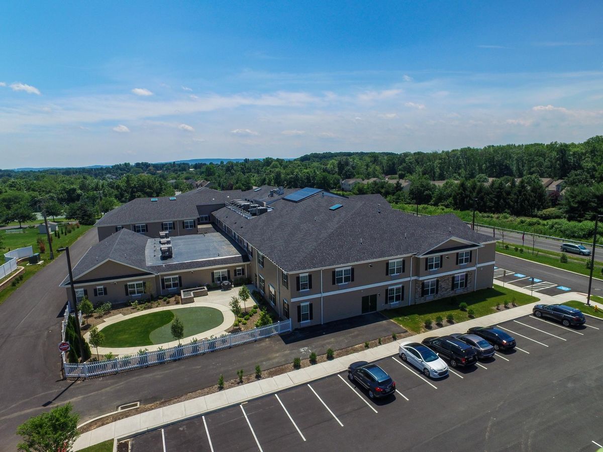 Aerial view of a large building with a parking lot on a sunny day.