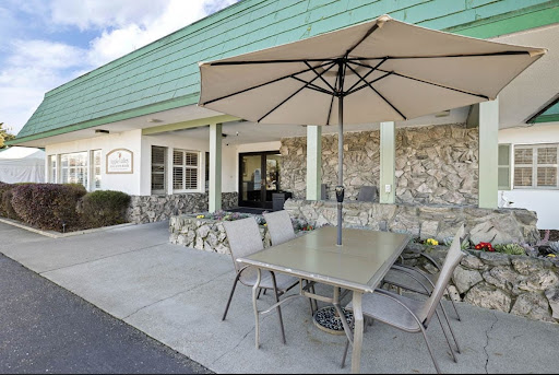 A cozy outdoor seating area with a table, chairs, and an umbrella, perfect for enjoying meals al fresco.