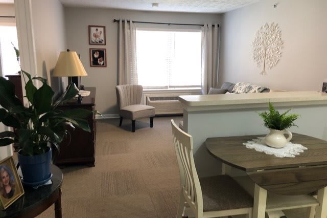 A cozy living room with a dining area featuring neutral tones and elegant furniture.