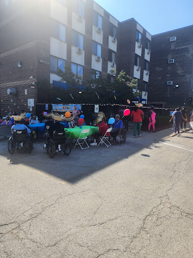 A vibrant community gathering with children dressed in colorful outfits enjoying the outdoors.