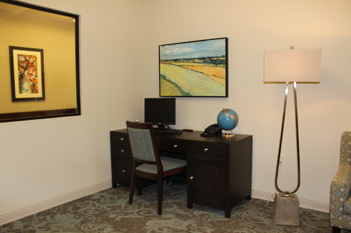 A modern office space featuring a desk with a computer, a globe, and artwork on the wall.