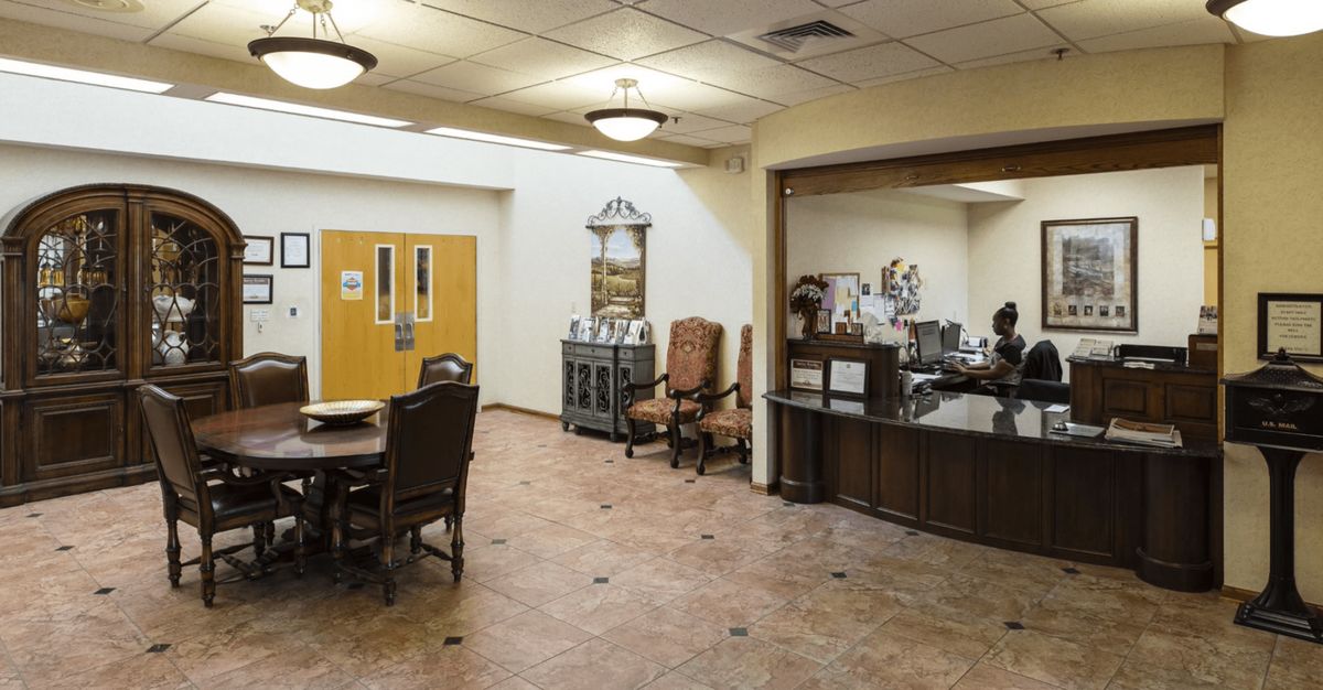 An office reception area with a desk, chairs, and decorative elements.