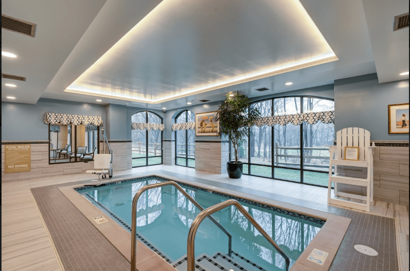 A luxurious indoor pool area with modern design and relaxation amenities.