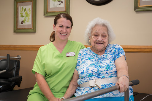 A caregiver and an elderly resident share a joyful moment together.