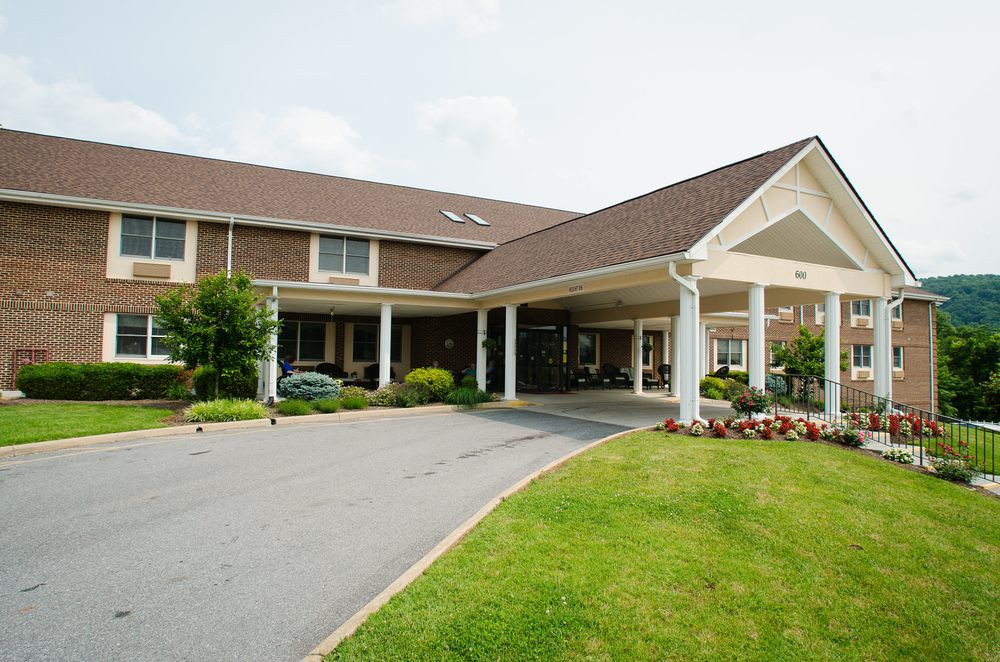 A residential building with a covered entrance and landscaped surroundings.
